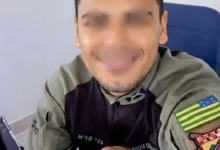 A Polícia Militar prendeu, em Aparecida, um homem suspeito de se passar por policial militar após ele tentar fugir de uma abordagem do Batalhão Maria da Penha. A investigação começou durante o acompanhamento de uma mulher assistida por Medida Protetiva de Urgência, quando os militares receberam informações sobre a conduta do suspeito. Segundo a PM, o homem usava uma suposta identidade funcional falsa e mantinha fotos em que aparecia com fardamento policial. Com esse material, ele teria se apresentado como integrante da corporação, embora não fizesse parte dos quadros da Polícia Militar. Diante da denúncia, o Serviço de Inteligência do Batalhão Maria da Penha iniciou levantamentos para confirmar as informações. Em seguida, as equipes fizeram diligências para localizar o investigado e esclarecer os fatos apontados durante a apuração. Durante a abordagem, os policiais deram ordem legal ao suspeito. No entanto, ele desobedeceu à determinação e tentou fugir. Pouco tempo depois, os militares conseguiram localizá-lo, contê-lo e conduzi-lo à delegacia. Polícia investiga uso de documento falso e fardamento Após a prisão, a PM encaminhou o suspeito à Central Geral de Flagrantes, onde ele foi autuado por desobediência. Mesmo assim, a ocorrência ainda terá novos desdobramentos, já que outros pontos levantados durante a ação serão investigados. Agora, a Polícia Civil deve apurar a suposta utilização de identidade funcional fraudada, além do uso indevido de fardamento policial. Os investigadores também vão verificar se o homem se apresentava à população como policial militar sem integrar a corporação. Além disso, a polícia quer saber se o suspeito usava a falsa identificação para obter vantagens, intimidar pessoas ou praticar outros delitos. Essa nova etapa da investigação deve apontar se outras vítimas foram afetadas pela conduta. O caso segue em apuração, enquanto os investigadores buscam entender como o homem teria conseguido os materiais usados para sustentar a falsa apresentação como policial militar.